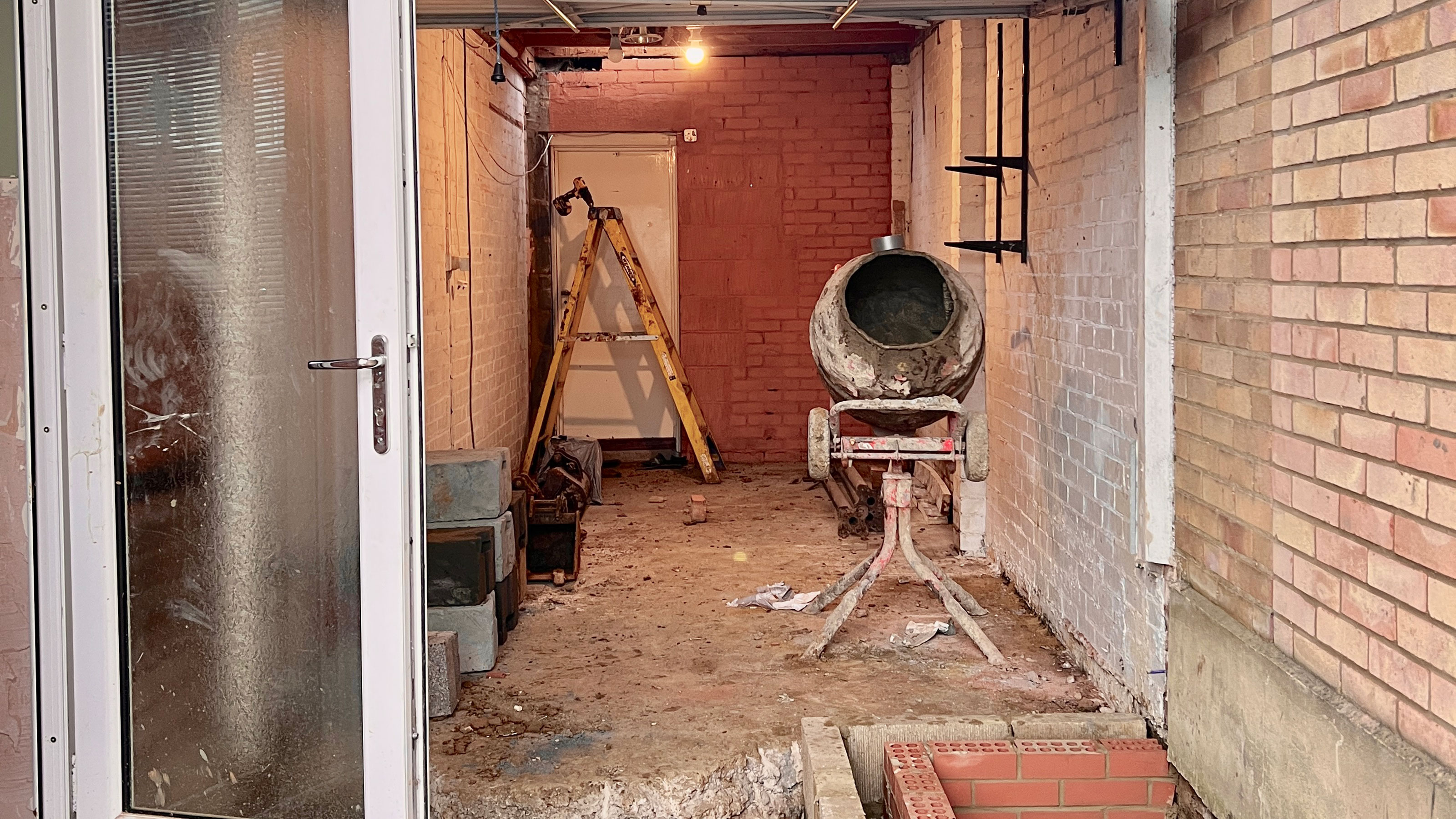 Exterior renovation and extension in full swing, with ladder and cement mixer