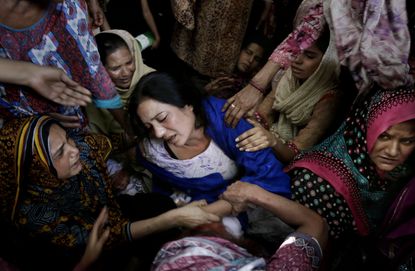 Women try to comfort a mother who lost her son in bomb attack in Lahore, Pakistan, Monday, March 28, 2016.
