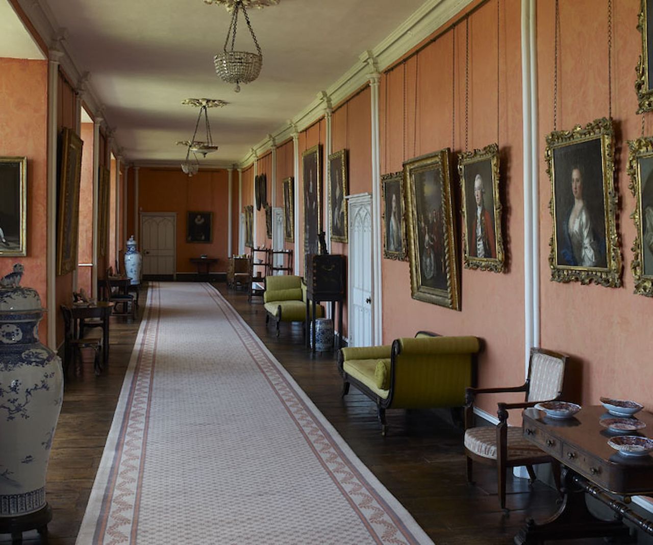 A hallway with old paintings lining the wall
