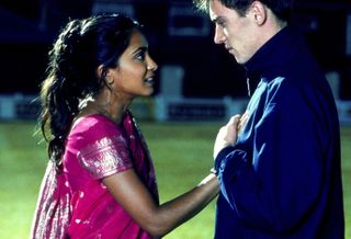 Parminder Nagra as a girl stands on a soccer field with her hand on a boy's heart in bend it like beckham