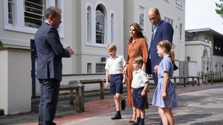 Prince George, Princess Charlotte and Prince Louis (C), accompanied by their parents the Prince William, Duke of Cambridge and Catherine, Duchess of Cambridge, are greeted by Headmaster Jonathan Perry