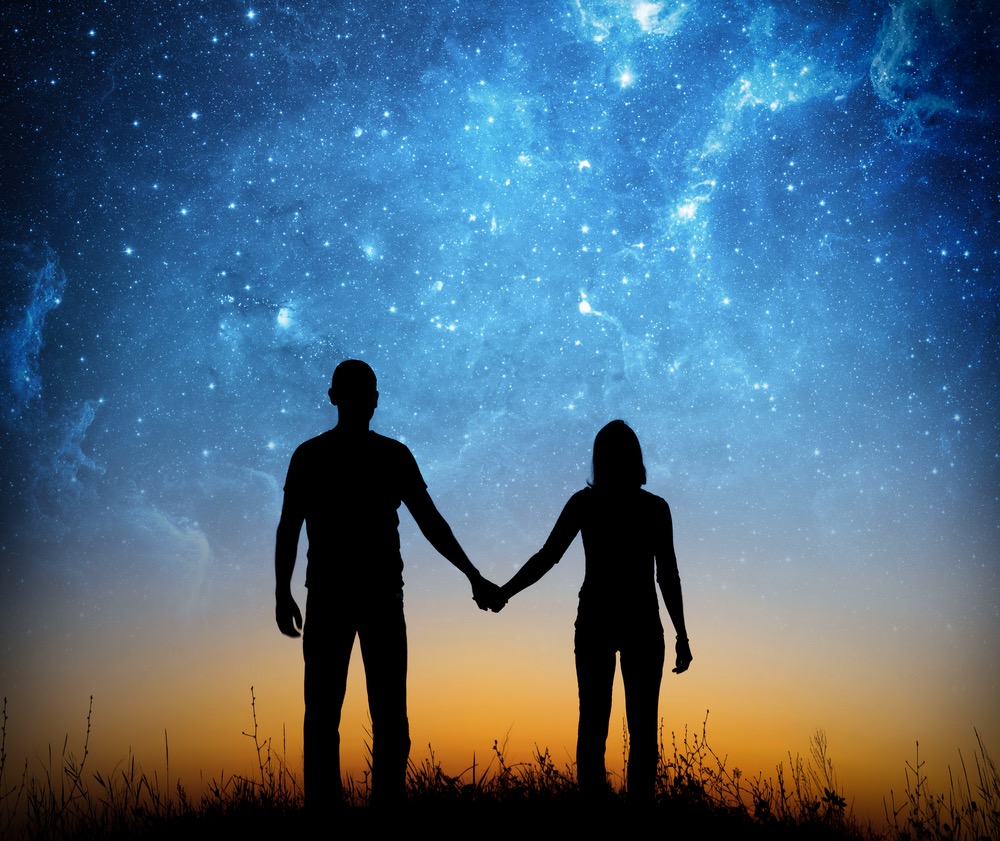 Silhouette of young couple under stars. The concept on the theme of love.