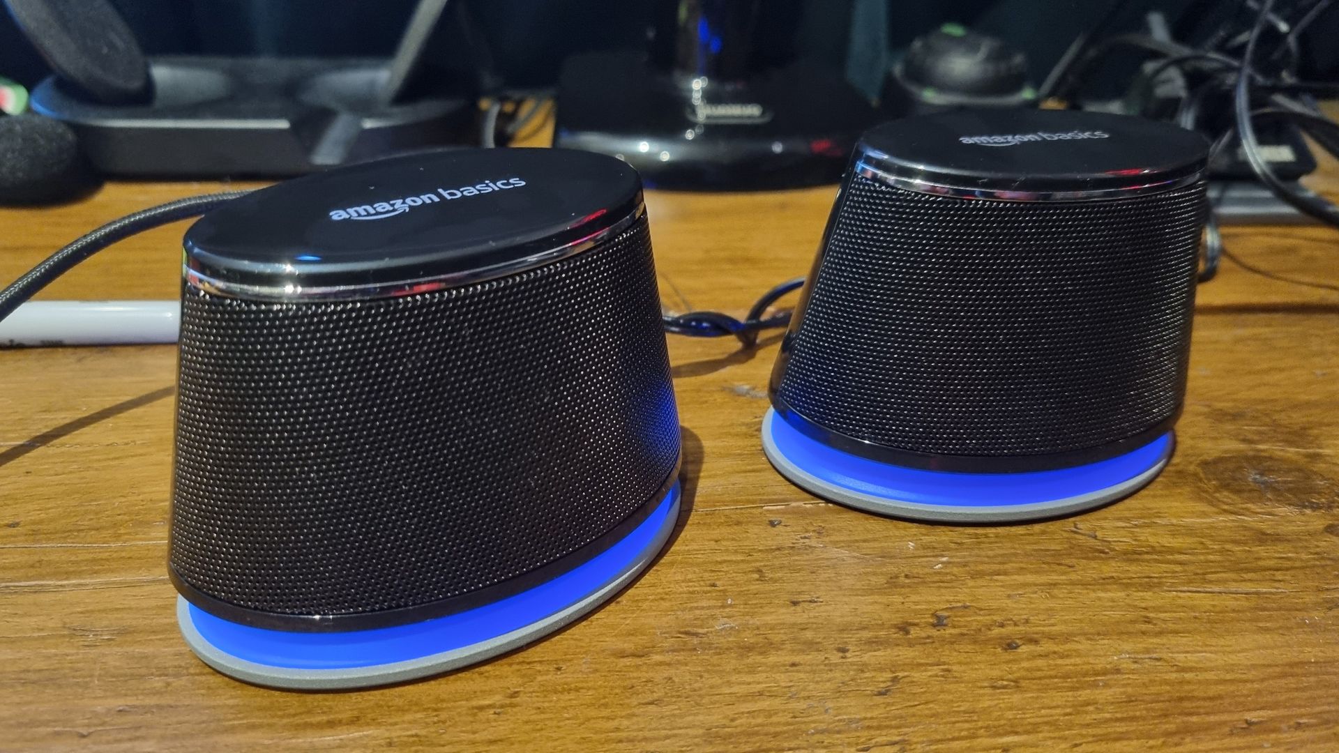 The Amazon Basics Stereo 2.0 speakers on a desktop, shot from various angles