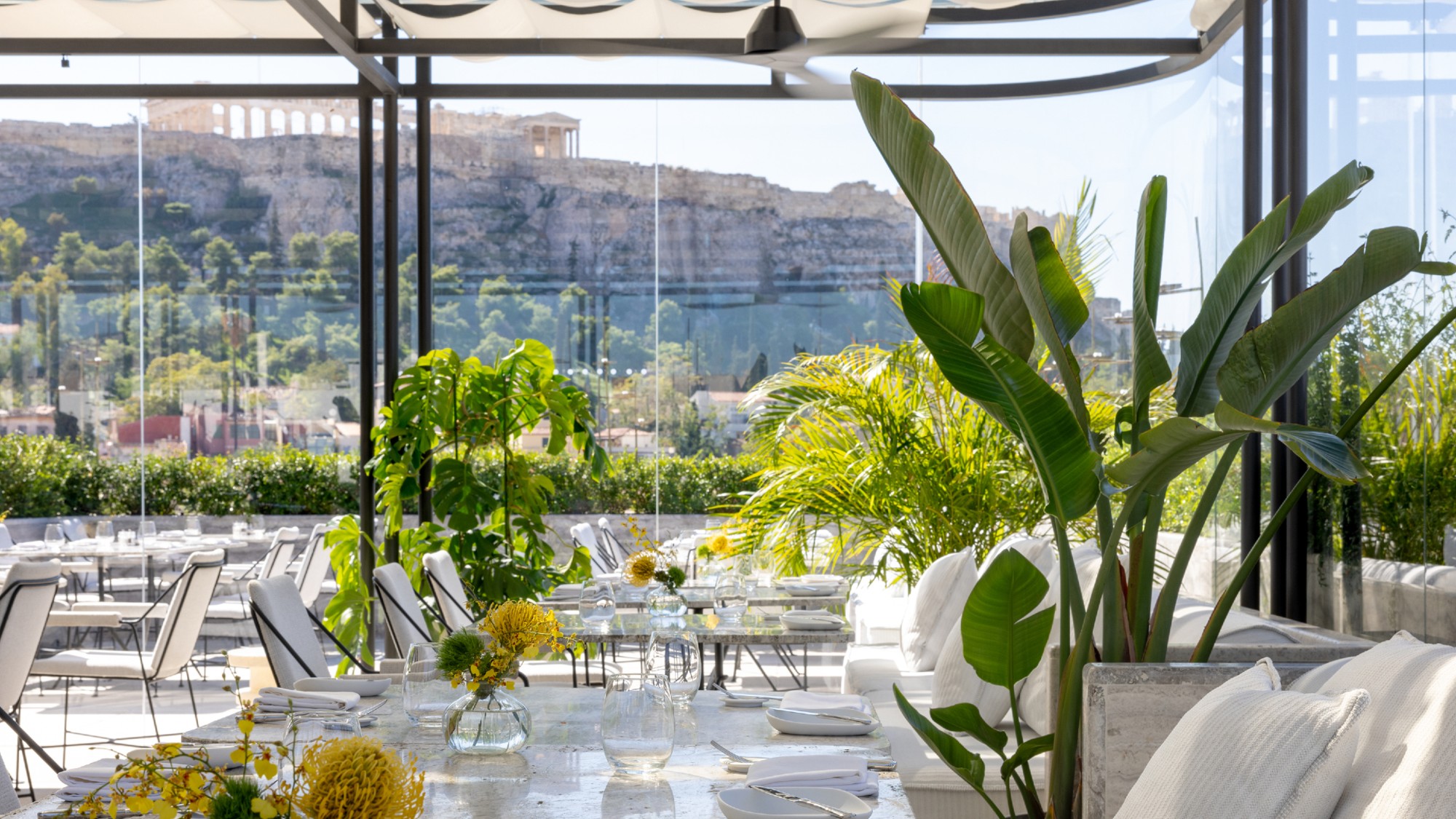 Glass-walled rooftop dining room at The Dolli at Acropolis, Athens
