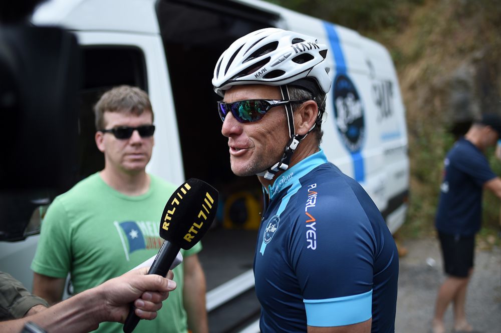 Lance Armstrong talks with a reporter upon his arrival in Rodez, southwest France, after riding a stage of The Tour De France for a leukaemia charity