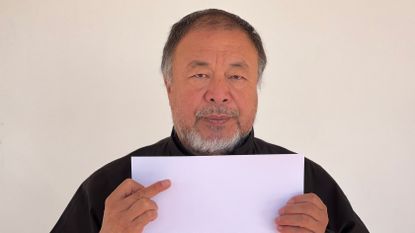 Portrait of Ai weiwei holding sheet of blank A4 paper