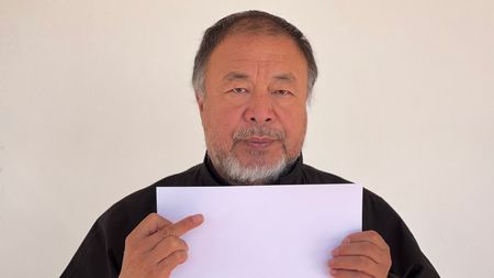 Portrait of Ai weiwei holding sheet of blank A4 paper