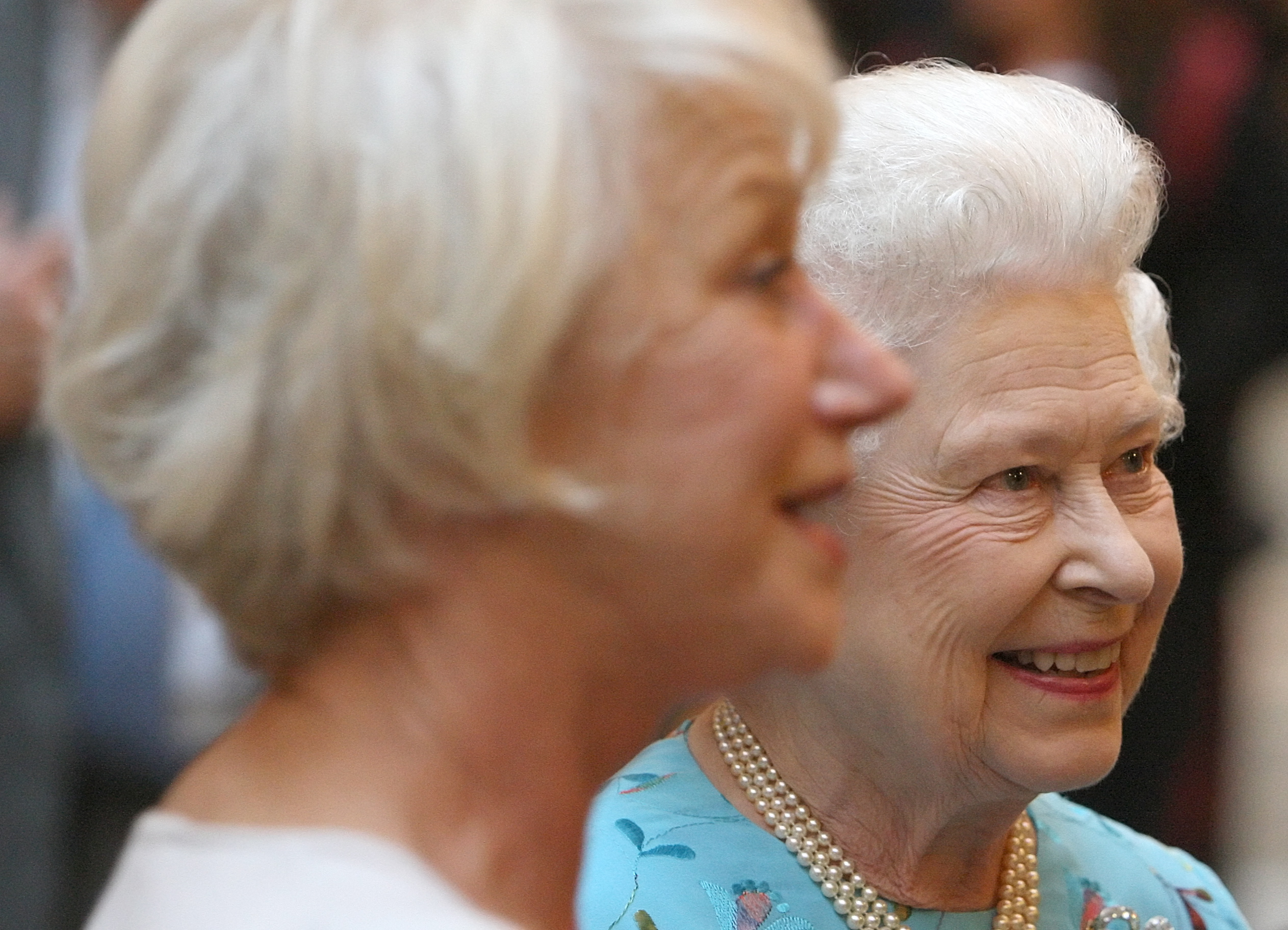 Helen Mirren standing next to Queen Elizabeth wearing a blue dress