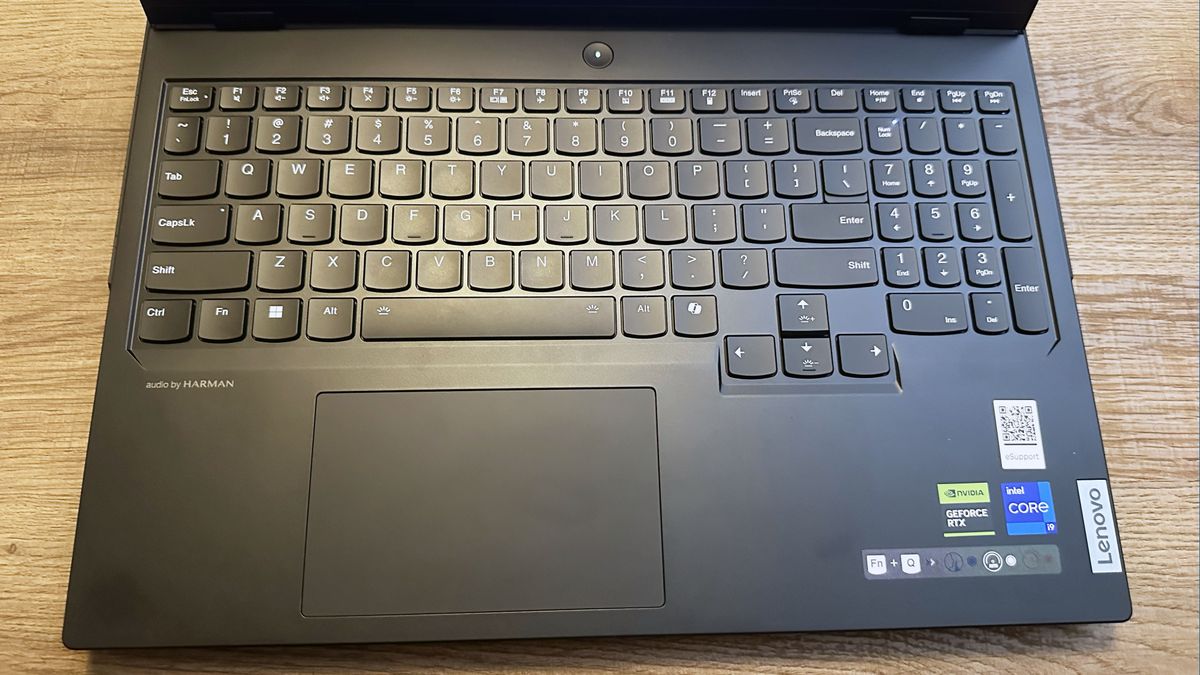 Lenovo Legion Pro 7i (Gen 9) open on a wooden table with a highlight on the keyboard.