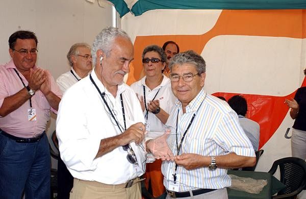 Vuelta director Victor Cordero (L) presents former Unipublic director Alberto Gadea with a token gesture
