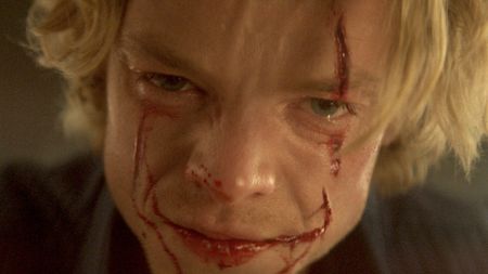 Tom Rhys Harries with his face cut in Clayface