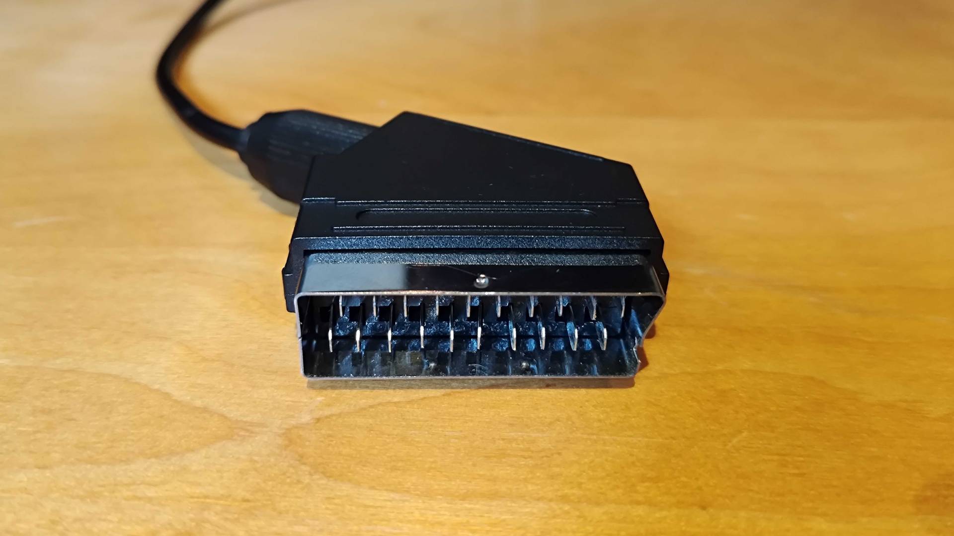 RGB SCART cable on woodgrain surface.
