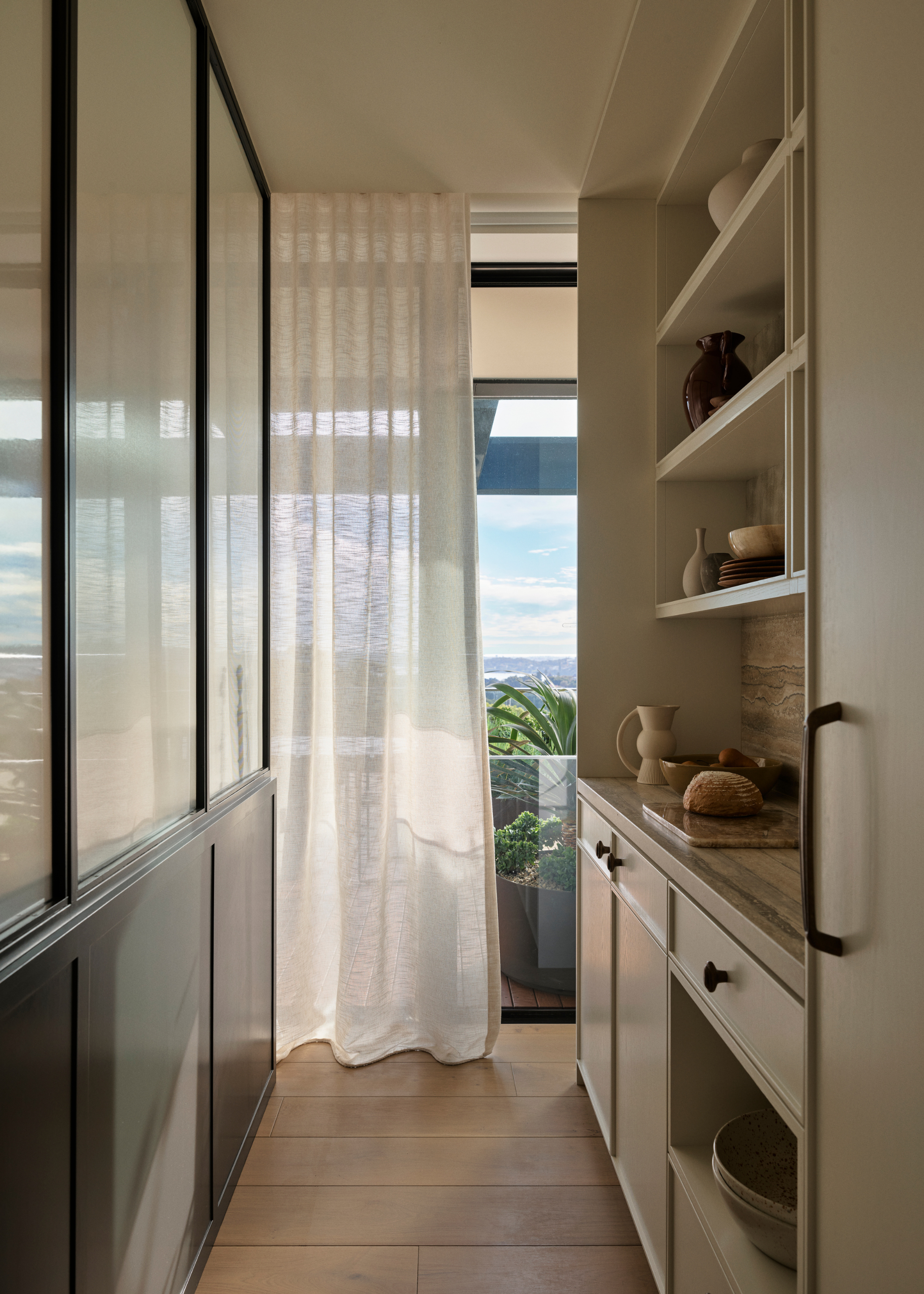 A small kitchen with floor-length windows and a curtain