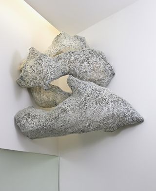 Grey sculptures attached to corner walls