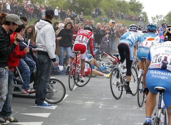 A spectator falls out of shot after being hit by a rider on the roads of Holland