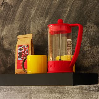 brown shelve with red coffee maker and yellow cup