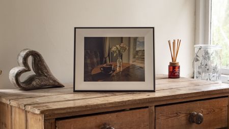 The Aura Ink 'E Ink' digital photo frame on a sideboard