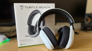 Turtle Beach Stealth 600 Gen 3 headset leaning against packaging on a wooden desk