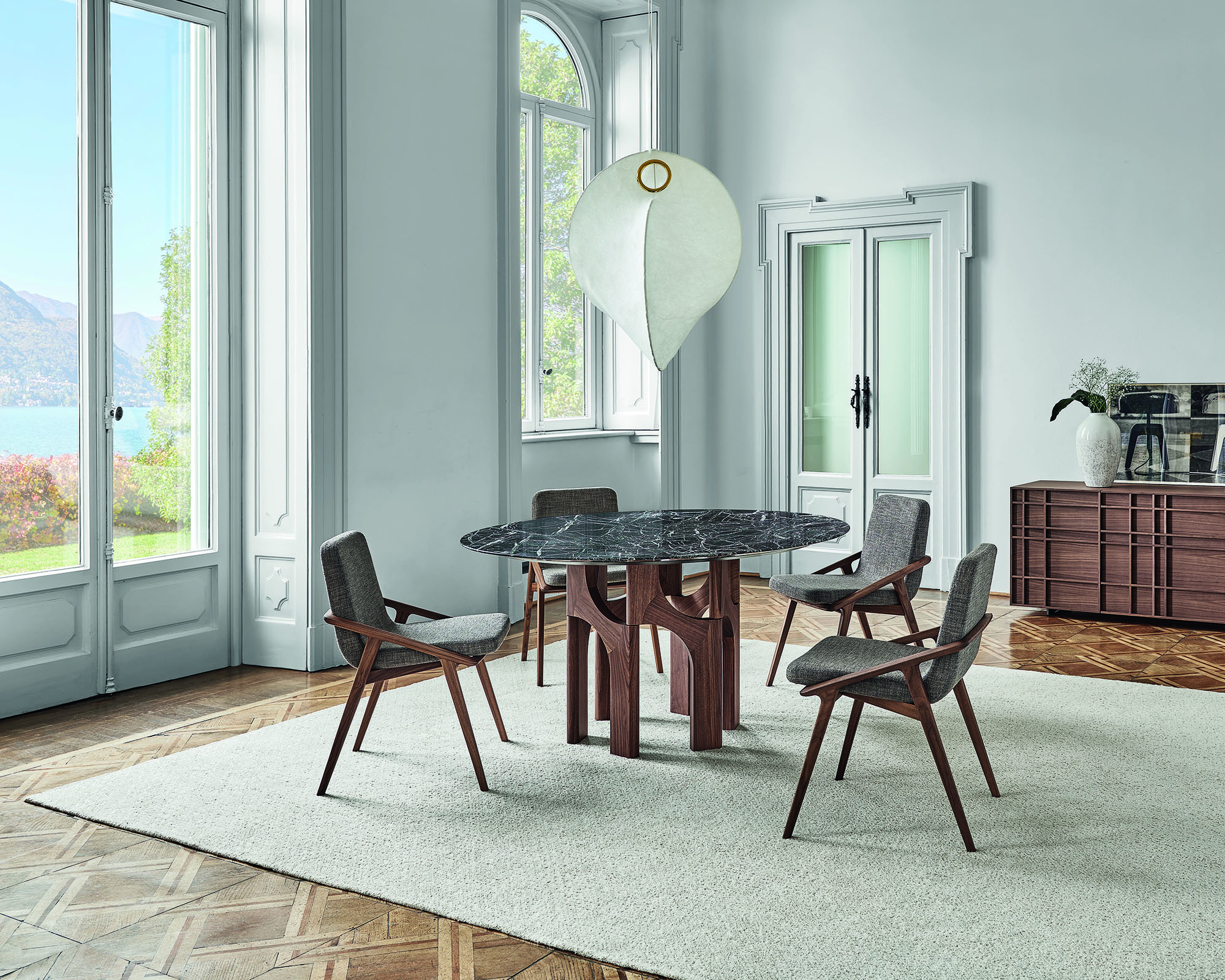 round dining table in a large white dining room with four chairs around it