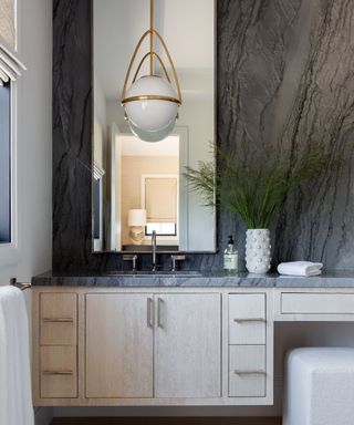 bathroom with dark marble backsplash and cube seat