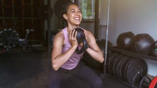 Woman performing goblet squat with kettlebell