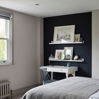 Grey bedroom with blue feature alcove wall, gallery pictures and white dressing table