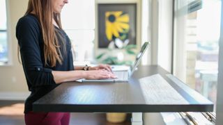 Woman using laptop on standing desk