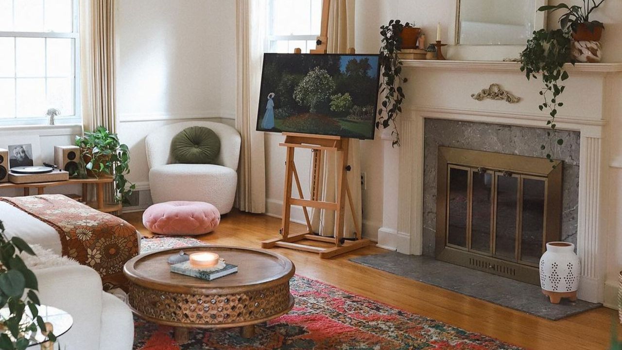 A small living room with a TV, red rug, accent chair, and coffee table