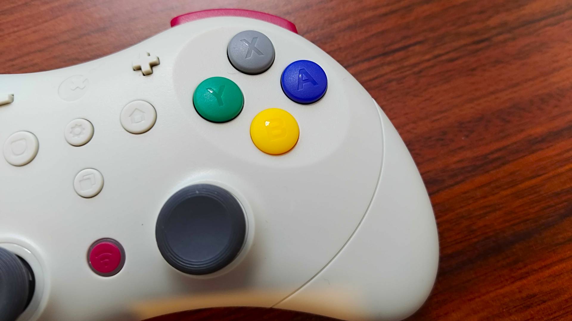 Close up of Gulikit Elves 2 Pro D-pad face buttons on woodgrain desk.