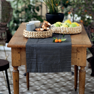 square wooden table and bucket of of cups and fruit