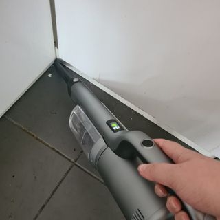 Person cleaning corner of wall with the crevice tool of the Roidmi RS60