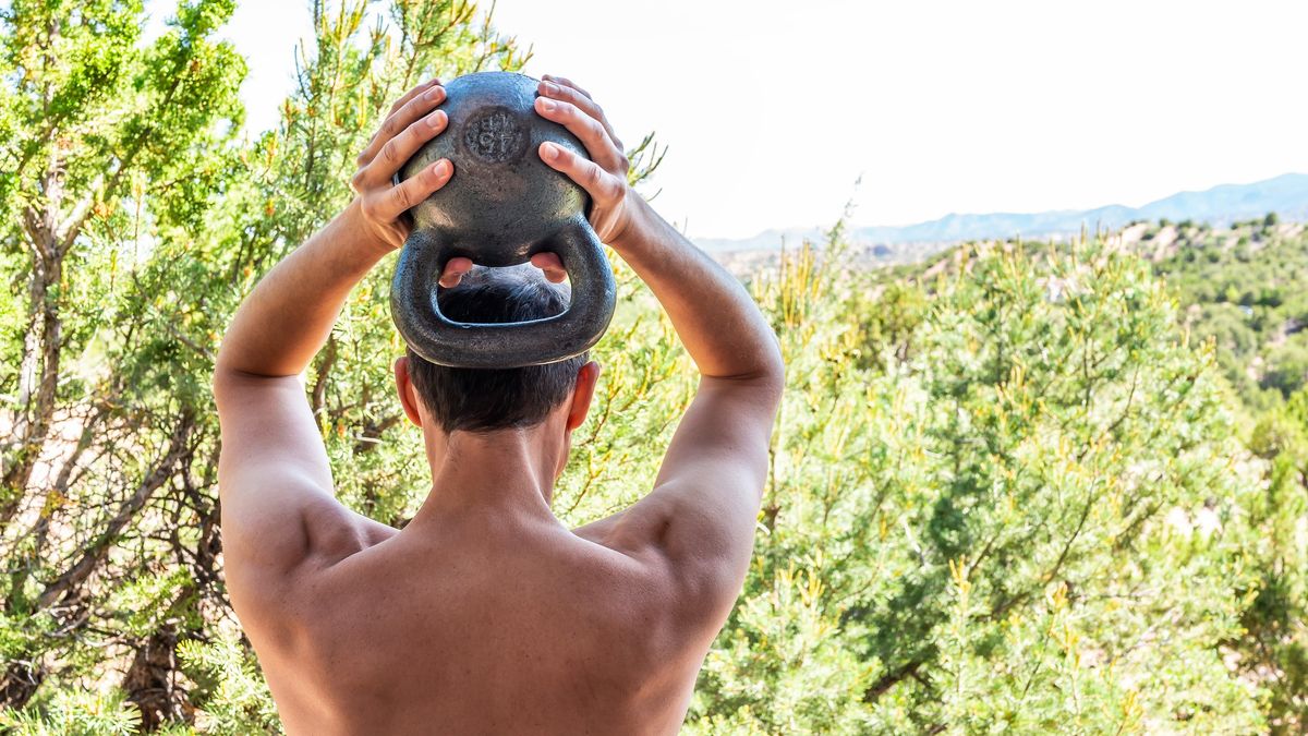 a photo of a man doing a tricep extension with a kettlebell