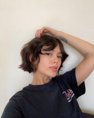 a woman taking a selfie with a wavy bob and fringe