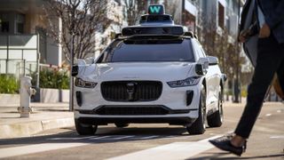 A picture of a Waymo car stopped at a crosswalk.