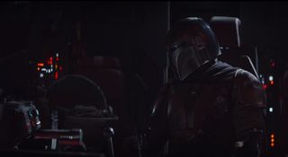 Mandalorian aboard his ship with cradle