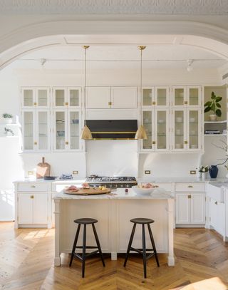 White kitchen with glass fronted cabinets and an island