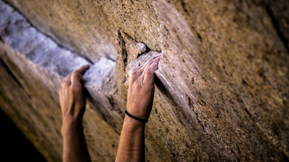 Rock climber&#039;s hands on a the famous bouldering roblem Iron Man Traverse in Bishop, California