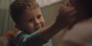 An adorable little boy reaches up to touch his babysitter's face, from Disney+ Launchpad short "Let's Be Tigers"