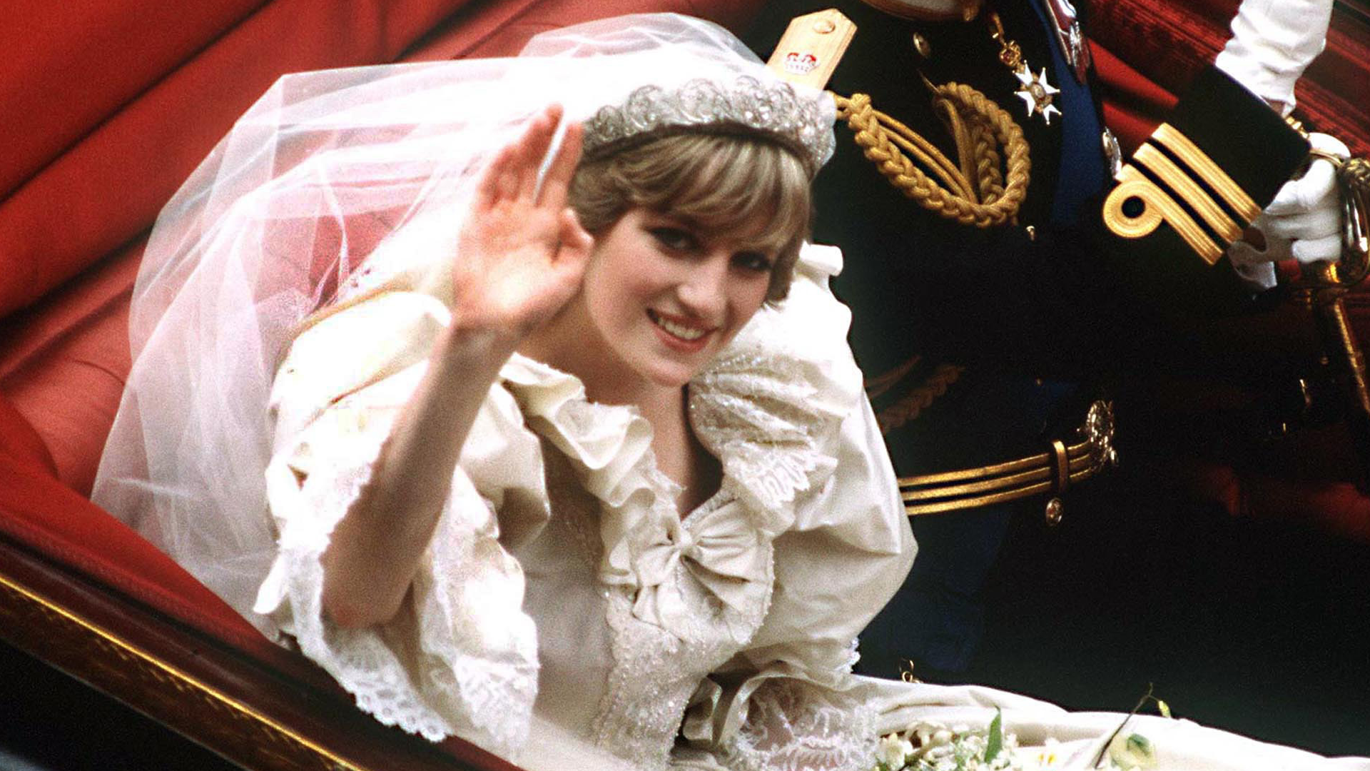 Princess Diana waving in her wedding dress and tiara from a carriage