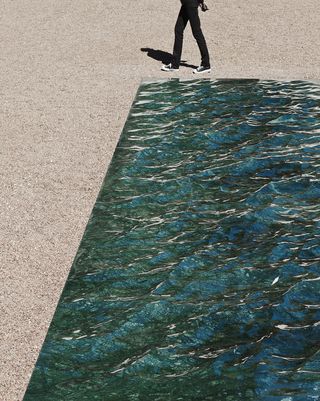 Man walking next to green marble