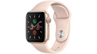 Apple Watch 5 GPS med gylden urkasse og beige/lyserød rem på hvid baggrund.