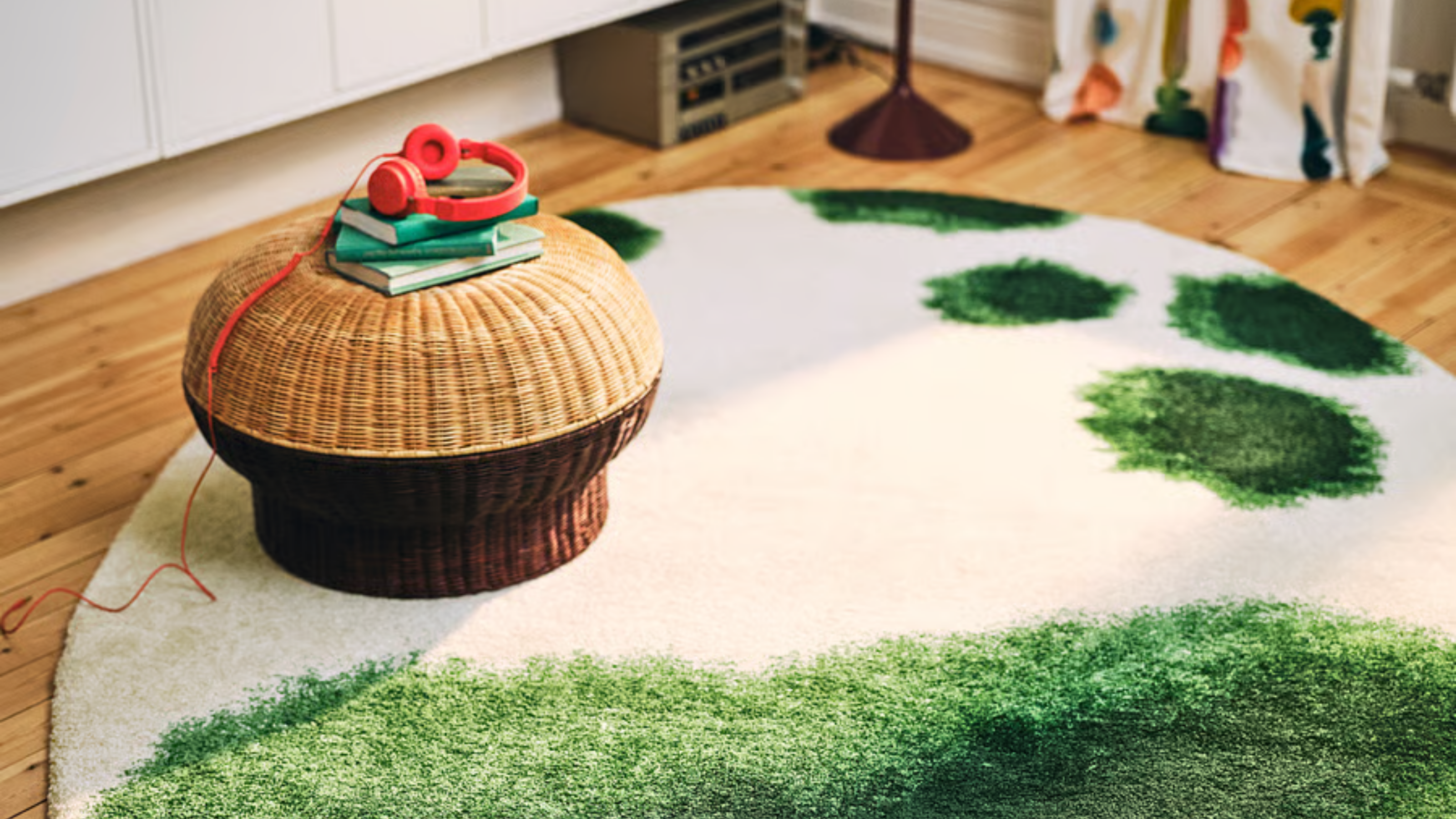 a rattan storage ottoman in a room with a green rug 