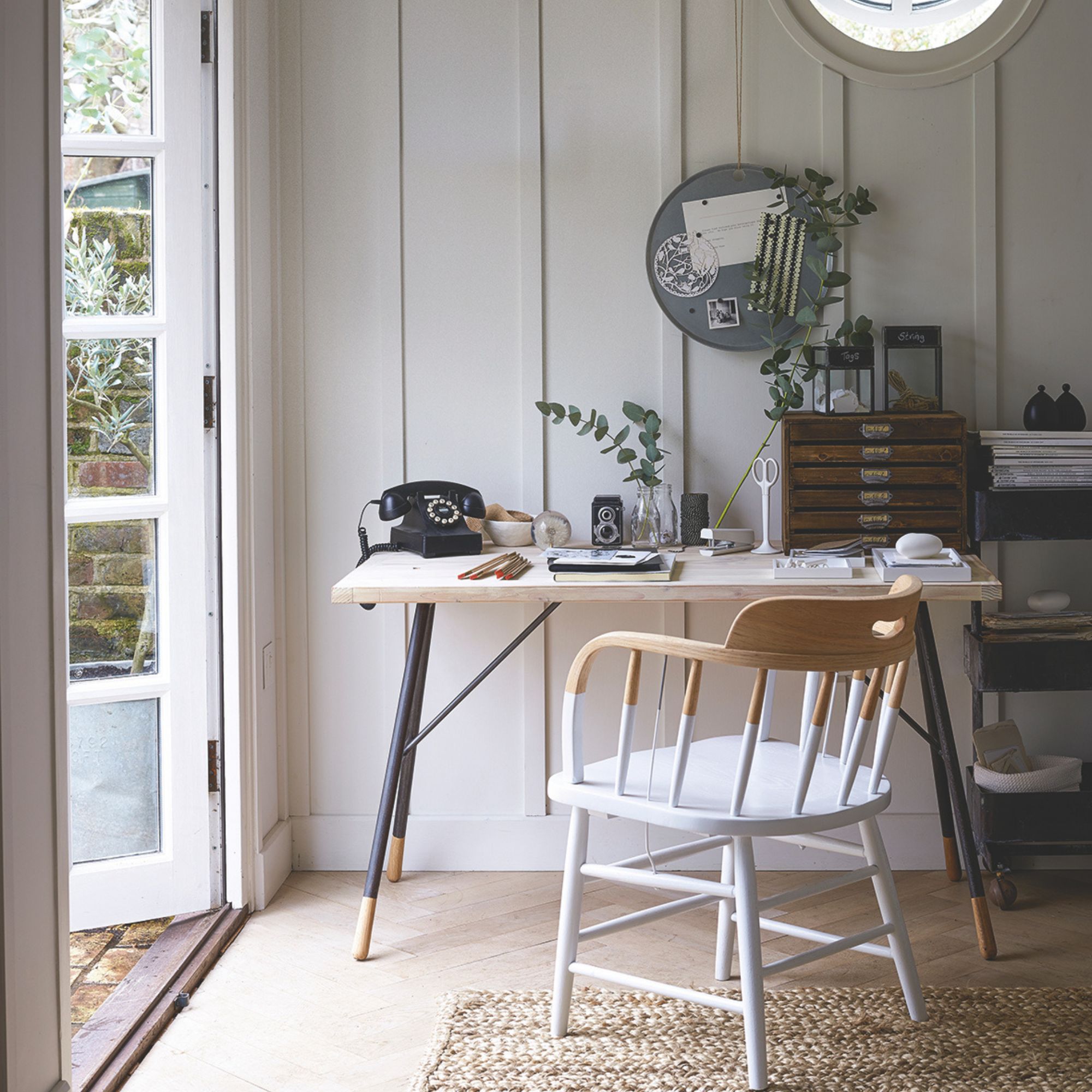 A home office with neutral accessories and wooden panelled walls