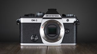 OM System OM-3 on a wooden surface