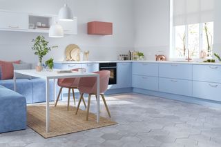 colourful kitchen with pink cooker hoods, blue cabinets and pink chairs