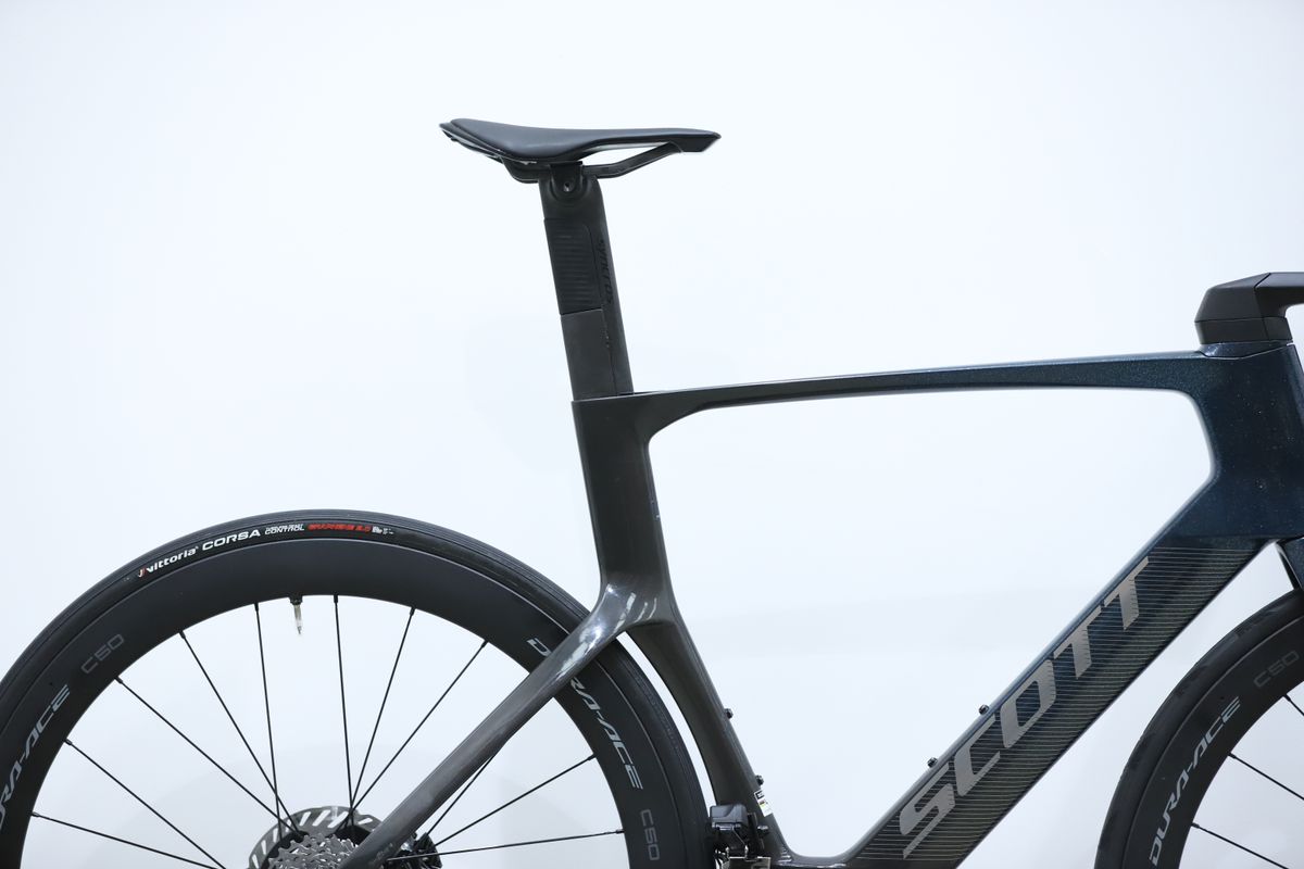 A blue Scott Foil RC Pro stands against a white wall