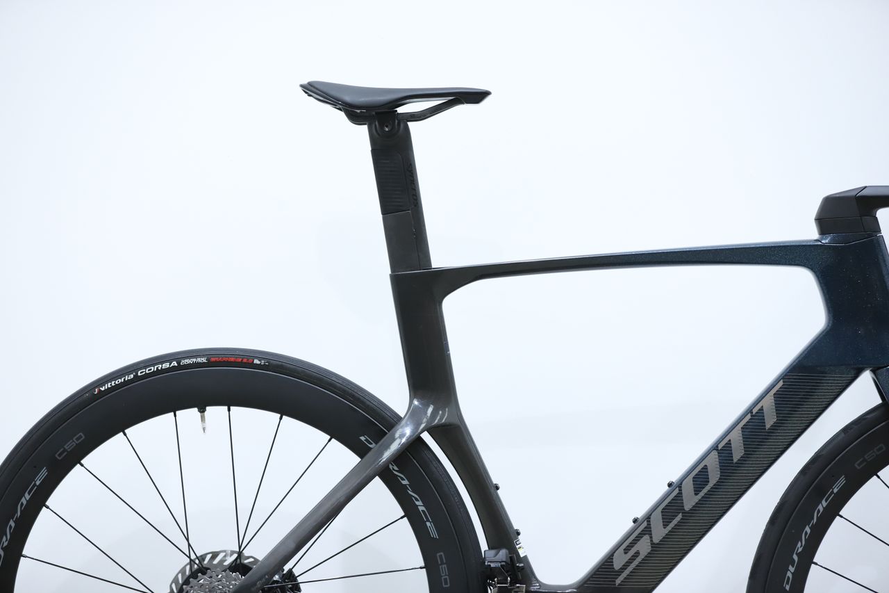 A blue Scott Foil RC Pro stands against a white wall