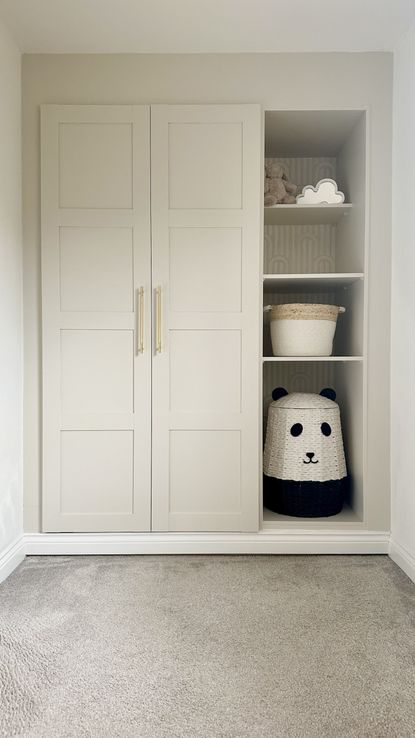 An IKEA PAX closet painted a cream color with open shelving decorated with kids' toys and baskets