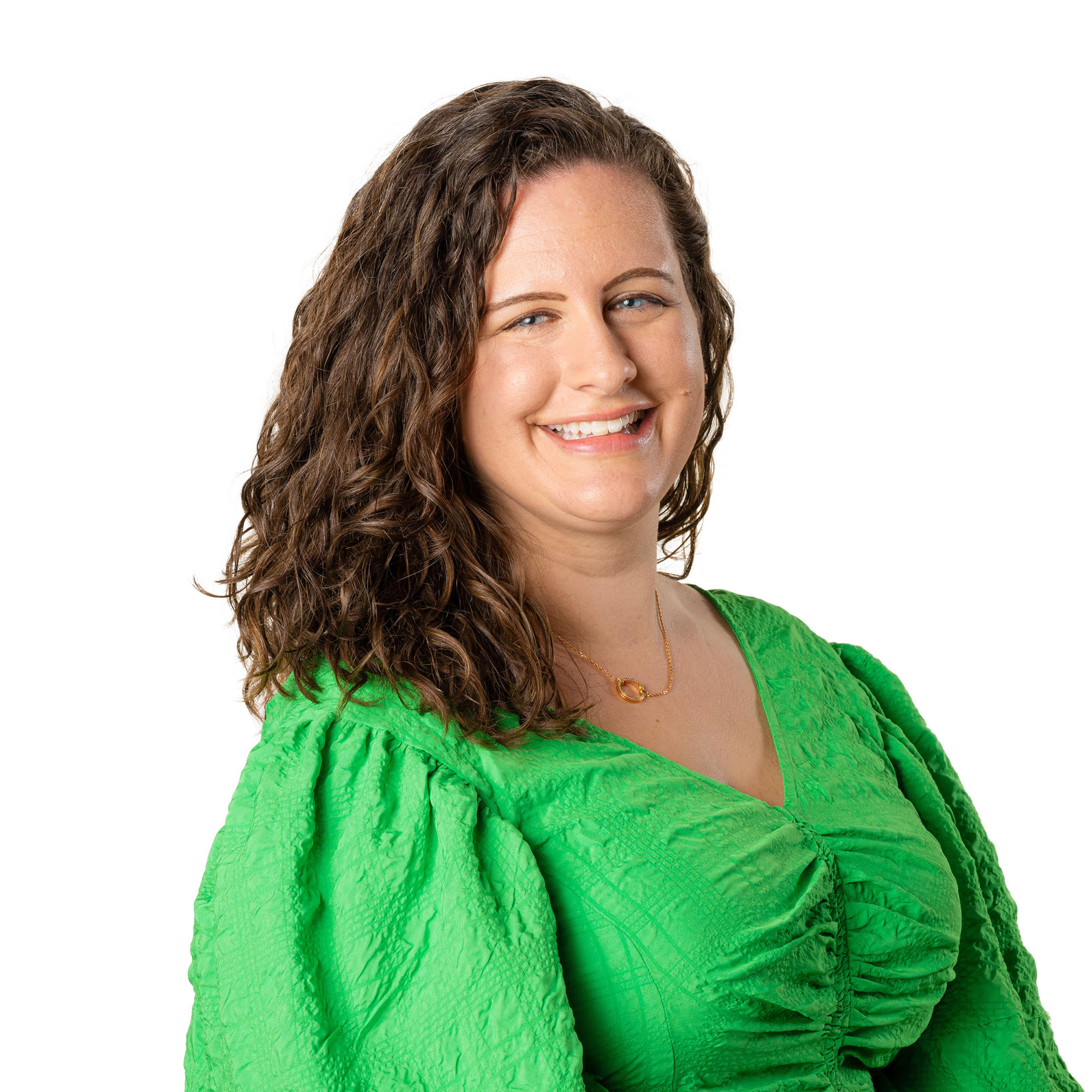 White woman with brown, curly hair, wearing bright green shirt and smiling with white background is Hannah Yang, Founder, CEO, and licensed psychologist at Balanced Awakening