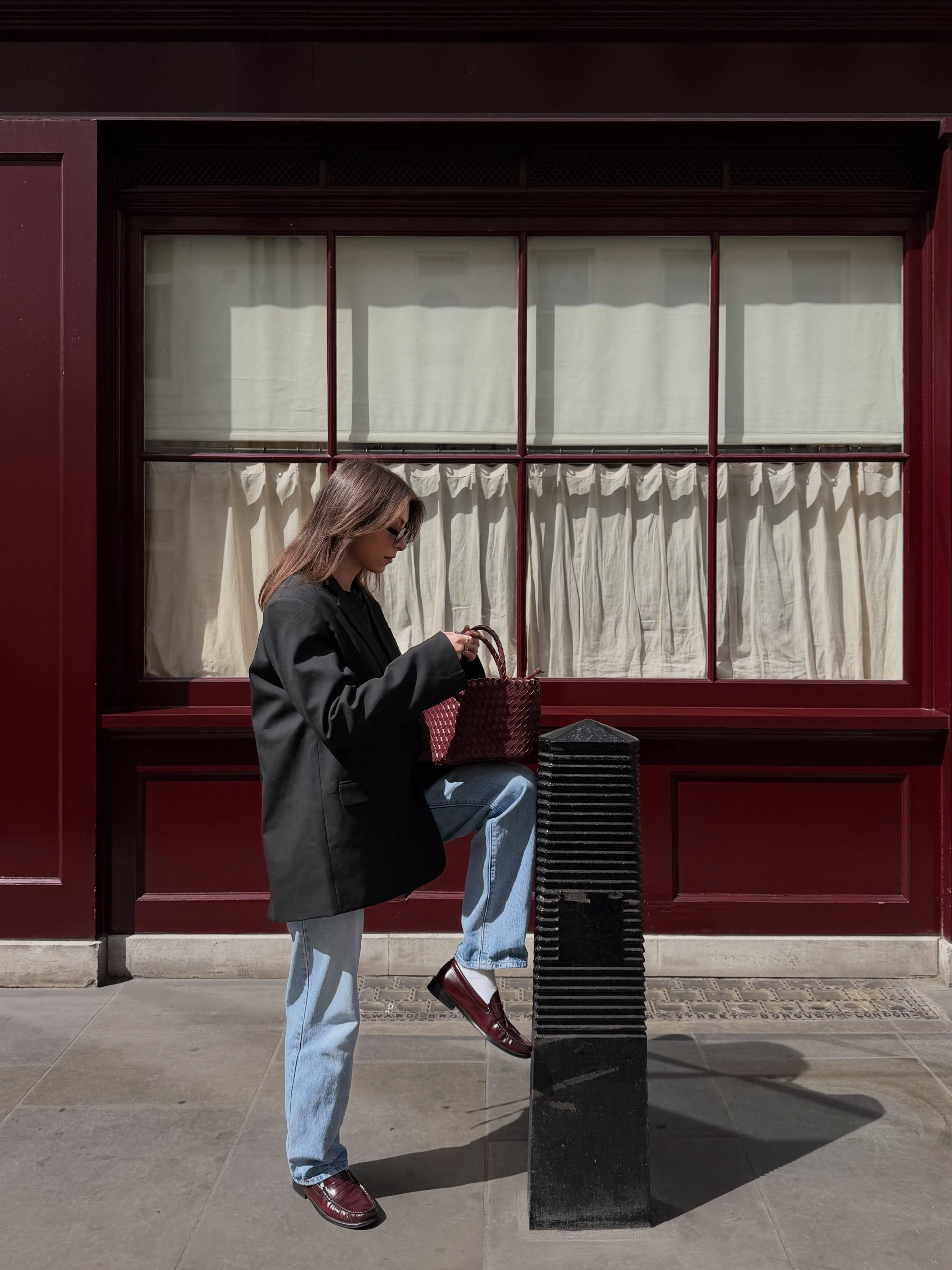 Woman wears blazer, jeans, loafers